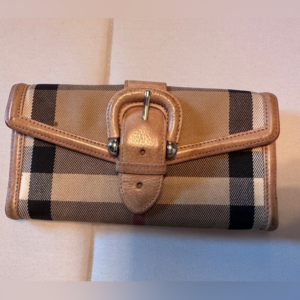 Authentic Burberry brown leather buckle wallet with snap closure.